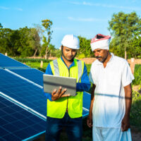 young technician checks the maintenance of the solar panels and discussing with farmer at field, technology in agriculture