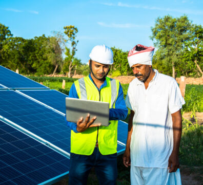 young technician checks the maintenance of the solar panels and discussing with farmer at field, technology in agriculture